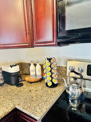 A kitchen with a Nespresso machine, two bottles labeled vinegar and oil, a spice rack, and a kettle on a stove. - The Rusty Road Runner-Spacious 4-bedroom house in superb Lake Havasu City (Lake Havasu City)