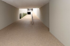 Ein Korridor mit Metallhandlauf, der zu einer Tür am Ende führt.