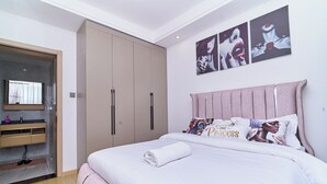 Quarto com cama, guarda-roupa, espelho e obras de arte na parede.