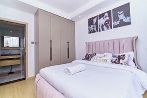 A bedroom with a bed, a wardrobe, a mirror, and artwork on the wall. - Leshwa House 1 is situated in the high end of Nairobi with tranquil and Ambience (Nairobi)
