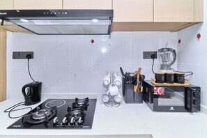 A kitchen with a gas stove, a coffee maker, a blender, and a mug rack. - Leshwa House 1 is situated in the high end of Nairobi with tranquil and Ambience (Nairobi)