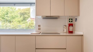 Eine Küche mit Schränken, einem Fenster, einem Feuerlöscher und einer Erste-Hilfe-Ausrüstung.