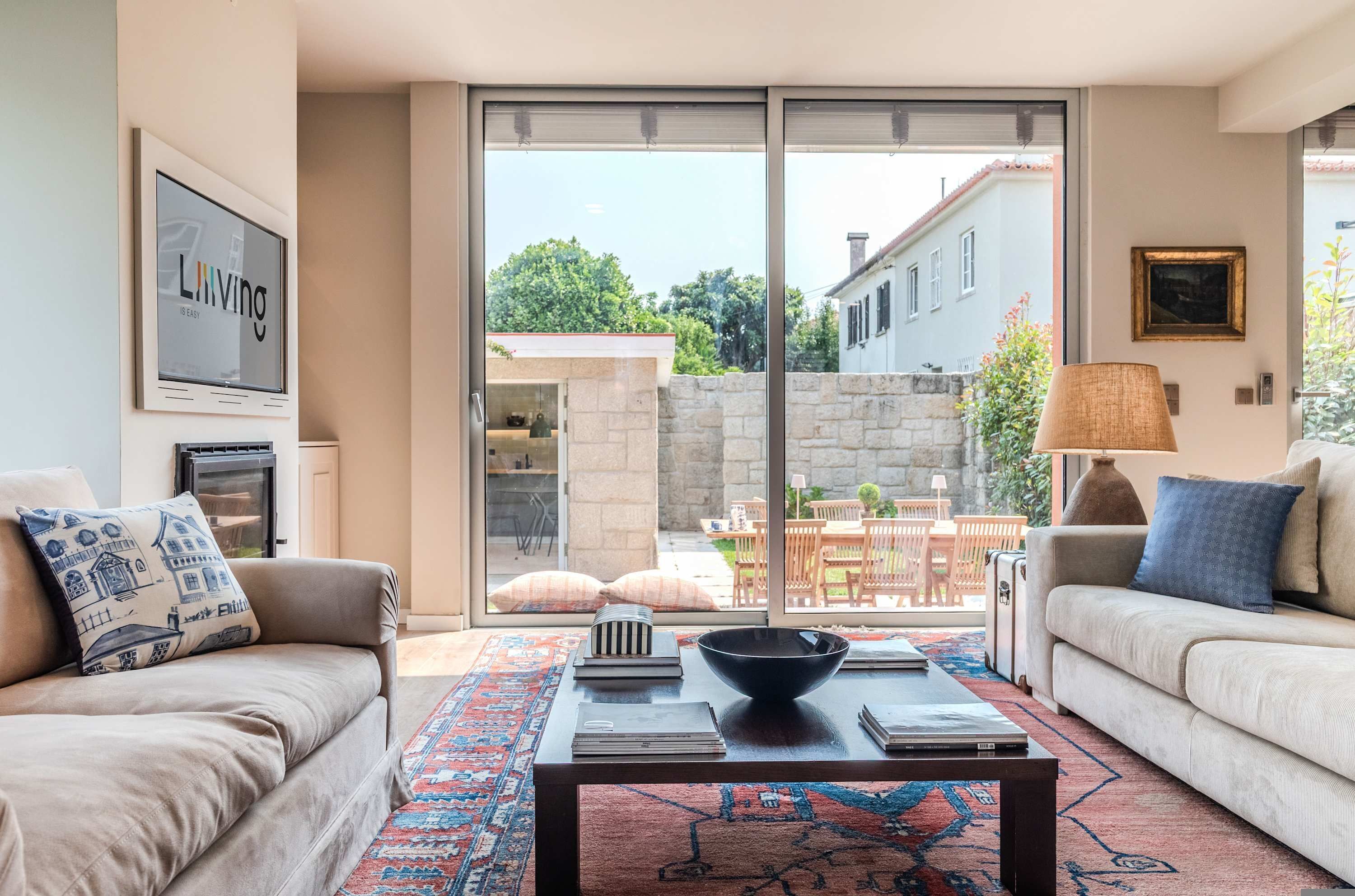 A living room with a sofa, a coffee table, and a view through a sliding glass door to an outdoor patio.