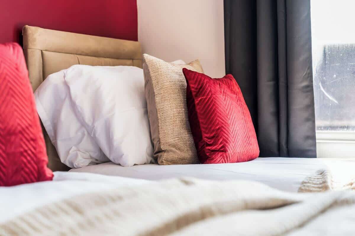 A bed with multiple pillows and a white bedspread.