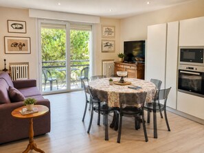 A modern kitchen with a dining area, a sofa, and a TV. - Casa delle anatre By Case al Lago (Desenzano del Garda)