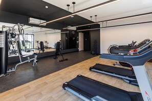 A gym with treadmills, weight machines, and a mirror wall. - StayHome Moema NexOne Pool & Gym (São Paulo)