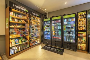 Ein Ladeninneres mit Regalen, gefüllt mit Snacks und Getränken, sowie Verkaufsautomaten mit der Aufschrift 'market4u'.