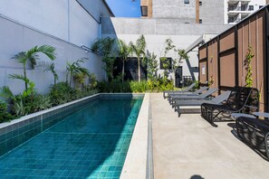 A swimming pool with lounge chairs and plants. - StayHome Moema NexOne Pool & Gym (São Paulo)