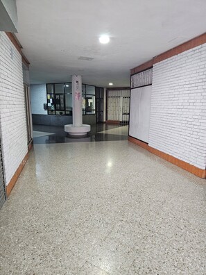 A hallway with white brick walls, a central pillar, and a tiled floor. - Solajero Apartment in Las Canteras (Las Palmas de Gran Canaria)