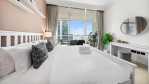 Una habitación de hotel moderna con una cama grande, un escritorio y vistas a la ciudad.
