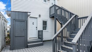 Eine Terrassenanlage mit Holztreppe und einer Tür, auf der das 'C' steht.