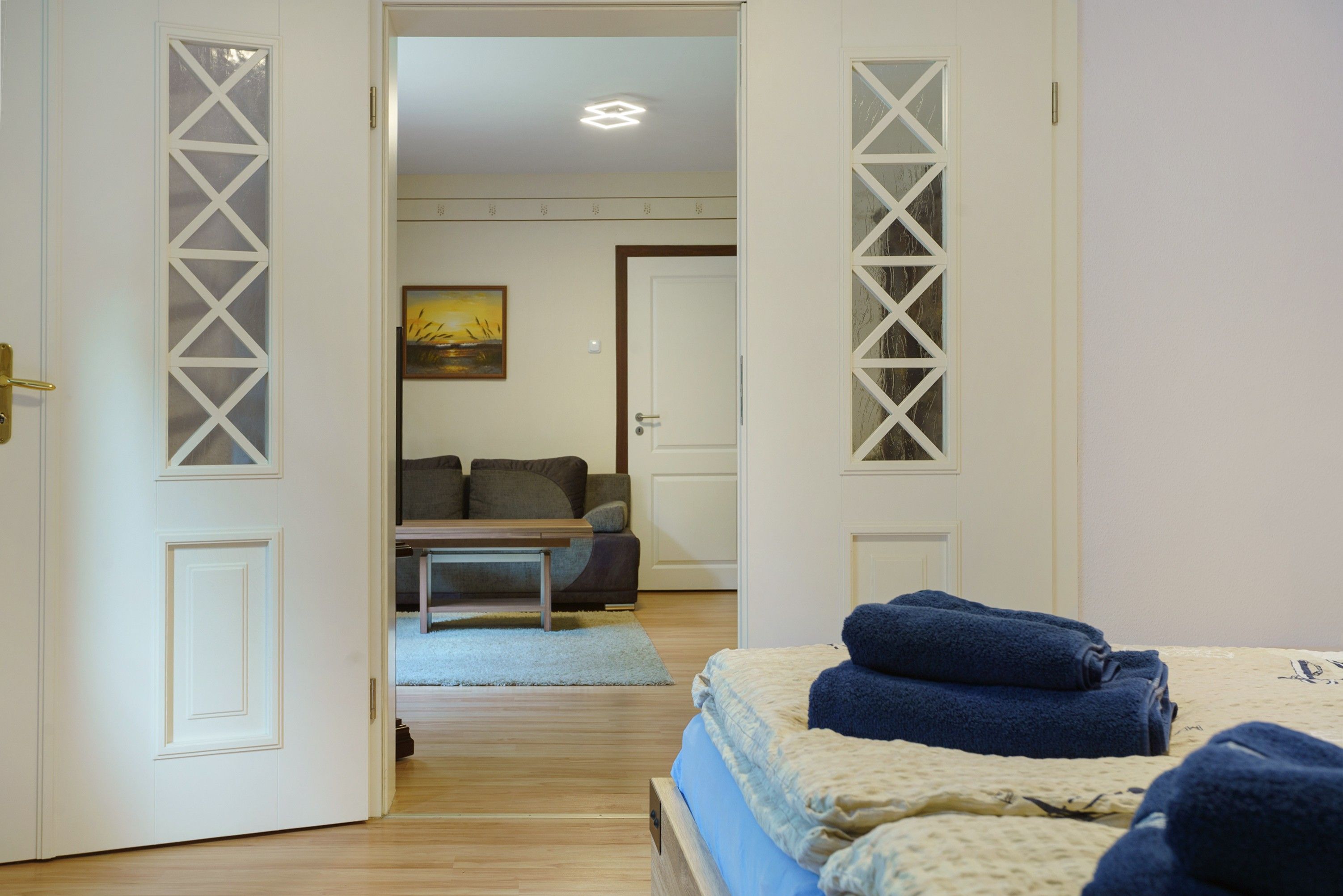 Habitación de hotel con una cama, un sofá, una mesita y un cuadro en la pared.