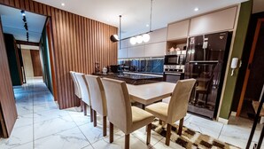 Una cocina moderna con una isla central, electrodomésticos integrados y un comedor con sillas.