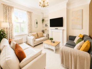 A living room with a sofa, a grey couch, a coffee table, and a television. - The Willow Chester | Parking | Canal Walks | Large Garden | Sleeps 8 (Chester)