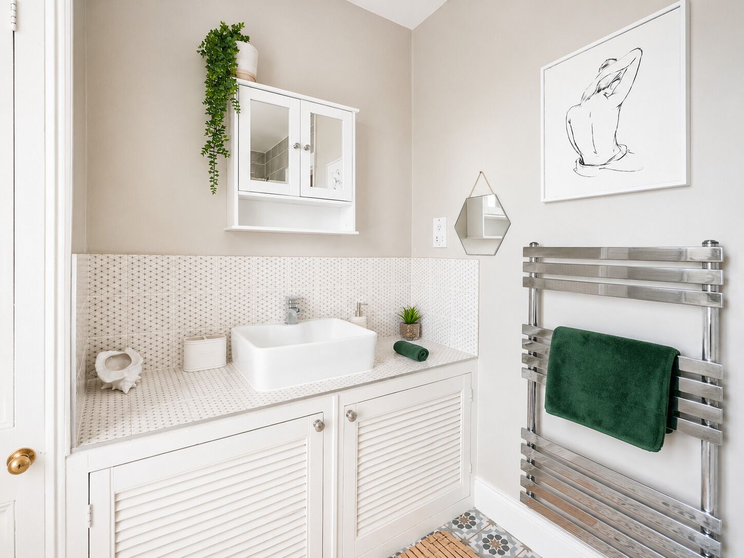 Une salle de bain avec un lavabo blanc, un miroir et un porte-serviettes.