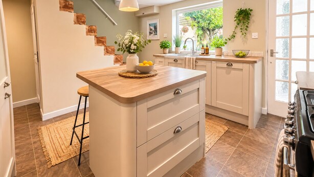 A modern kitchen with a central island, a built-in stove, and a window providing natural light. - The Willow Chester | Parking | Canal Walks | Large Garden | Sleeps 8 (Chester)