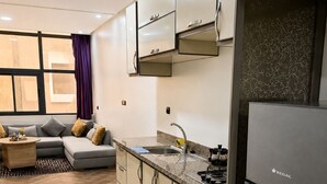Una cocina moderna con refrigerador, armarios y piso con patrón de espiga.