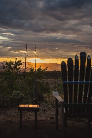 Ein Stuhl, der auf den Sonnenuntergang ausgerichtet ist, mit einer Bank im Vordergrund.
