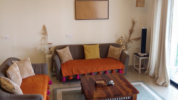 A living room with a sofa, armchair, coffee table, and a chandelier. - The Grove - Kudrat's Nilaya (Sea view apartment in Palolem) (Canacona)