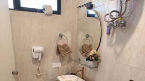 A bathroom with a white toilet, a glass shelf with toiletries, a towel rack, and a hairdryer. - The Grove - Kudrat's Nilaya (Sea view apartment in Palolem) (Canacona)