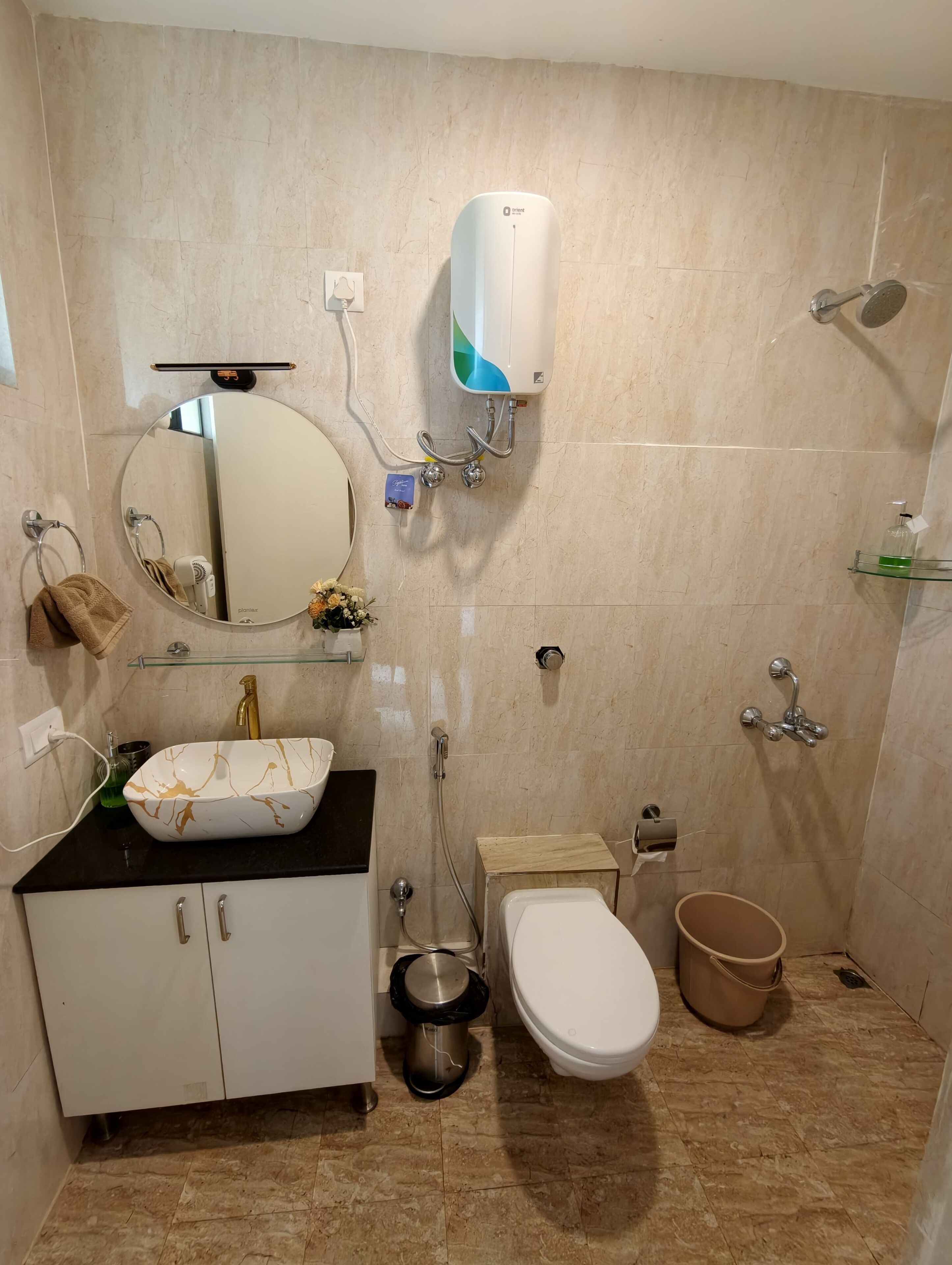 A bathroom with a sink, mirror, towel rack, toilet, bidet, and shower.