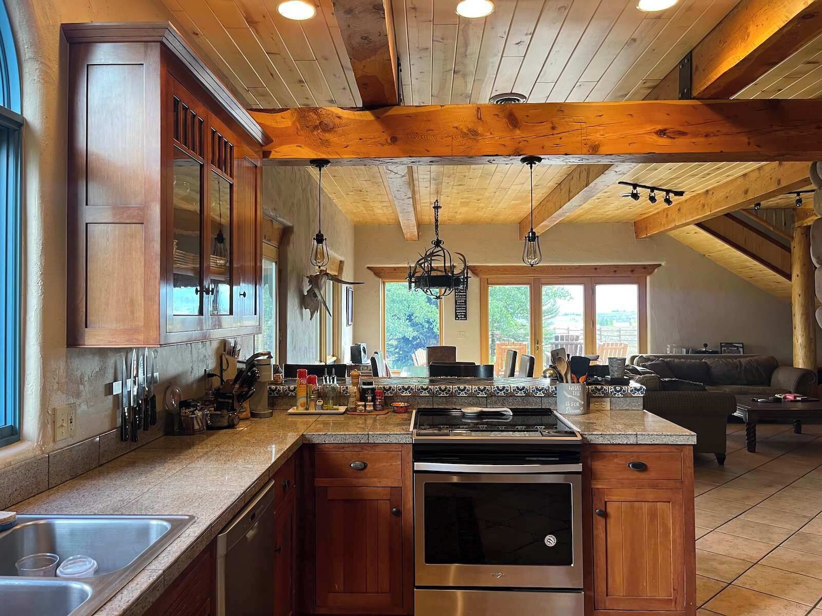 A spacious kitchen with wooden cabinets, a stainless steel stove, and a large island.