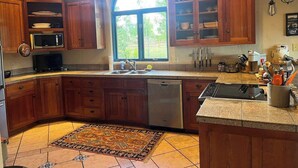 A kitchen with wooden cabinets, a built-in microwave, a dishwasher, and a large window providing natural light. - Studley Ranch-Private hot tub and pet friendly (Crested Butte)