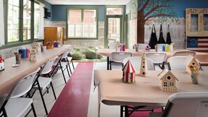 Un aula con mesas, sillas y elementos decorativos educativos.
