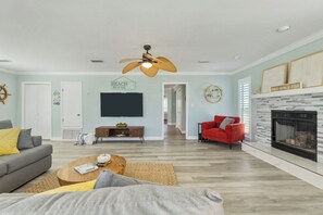Ein Wohnzimmer mit Kamin, Fernseher und einem roten Sessel.