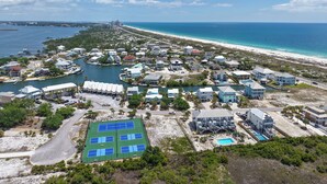 Vista aérea de um resort costeiro com vários edifícios, uma marina e uma praia.
