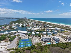 Luftaufnahme eines Küstenresorts mit mehreren Gebäuden, einer Marina und einem Strand.