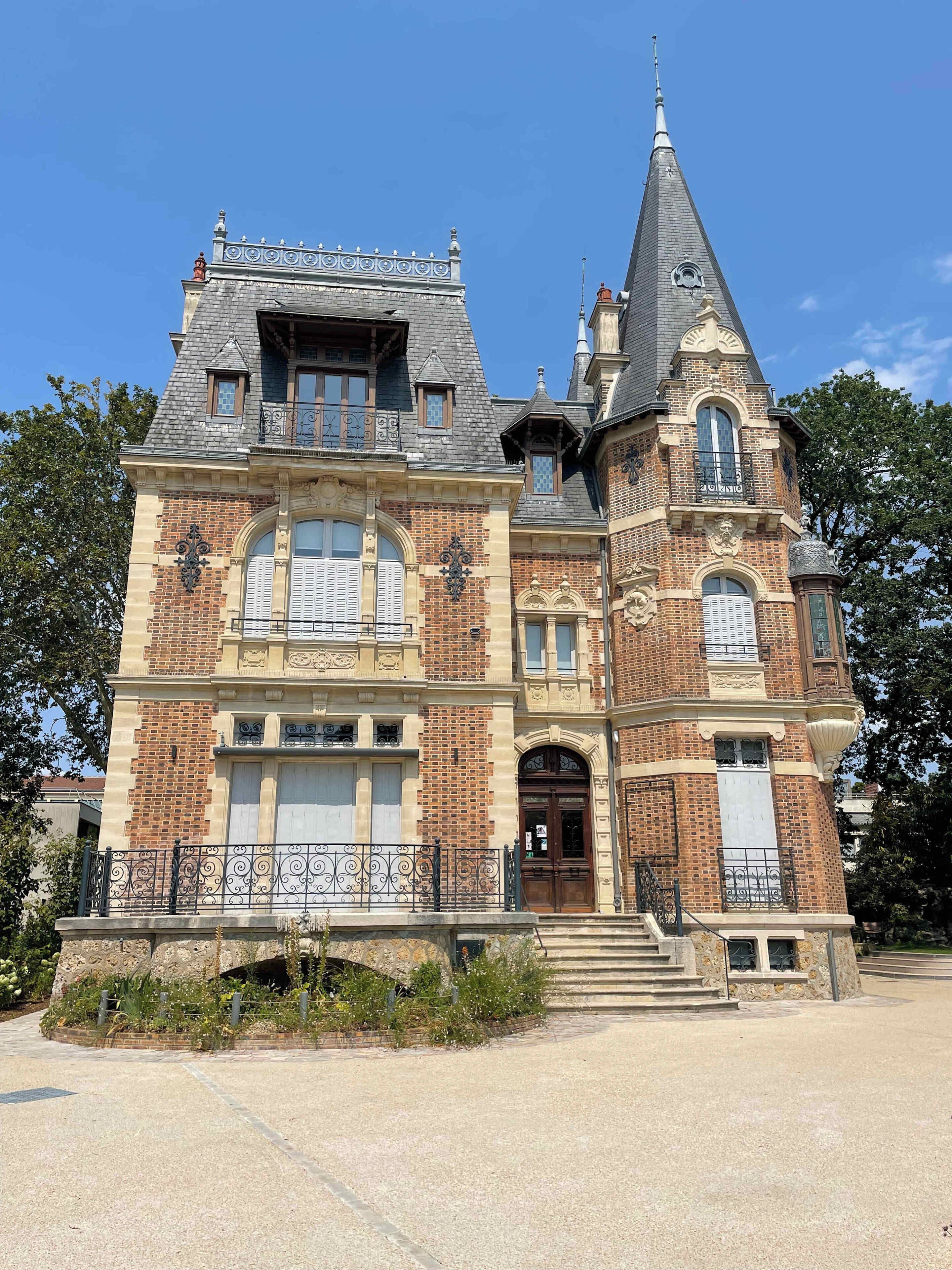 Un grand bâtiment historique, doté d’une tour imposante, de nombreuses fenêtres et d’une entrée monumentale.