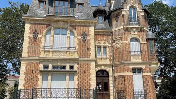 Un grand bâtiment historique, doté d’une tour imposante, de nombreuses fenêtres et d’une entrée monumentale.