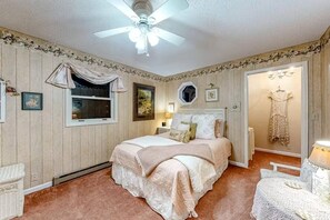 A bedroom with a bed, a ceiling fan, a window, and a door leading to another room. - The Dragonfly Main House (South Fork)