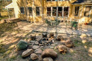 Une maison dotée d’un patio aménagé avec des meubles d’extérieur et un foyer.