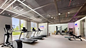 Uma academia com esteiras, bicicleta ergométrica e aparelhos de musculação.