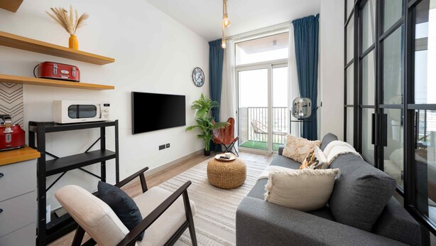 Uma sala de estar moderna com um sofá, uma TV, uma cafeteira e uma planta.