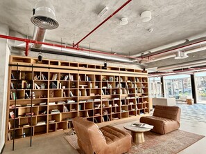 Eine moderne Bibliothek mit einem großen Bücherregal, Ledersesseln und einem Couchtisch.