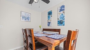 Ein Esszimmer mit Holztisch, Stühlen und Bildern an den Wänden.