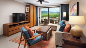 Una sala de estar moderna con televisor de pantalla plana, mueble de madera para entretenimiento, un conjunto de sofás, una mesa de centro y un balcón con vistas panorámicas.