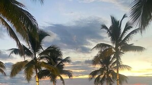 A swimming pool with a view of the ocean and palm trees. - Luxury Beachfront | Corner Condo | Amazing Pools (Puerto Vallarta)