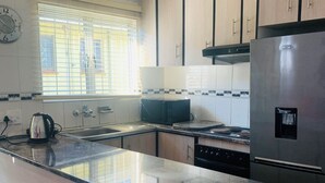 Habitación doble de lujo, patio | Cocina privada | Refrigerador, microondas, tostadora y Artículos de limpieza