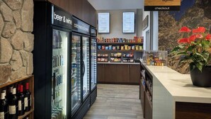 Ein Check-out-Bereich mit einem Schild für 'marketplace express' und einem Kühlbereich mit der Aufschrift 'Bier & Wein' und 'kalte Snacks & Getränke'.