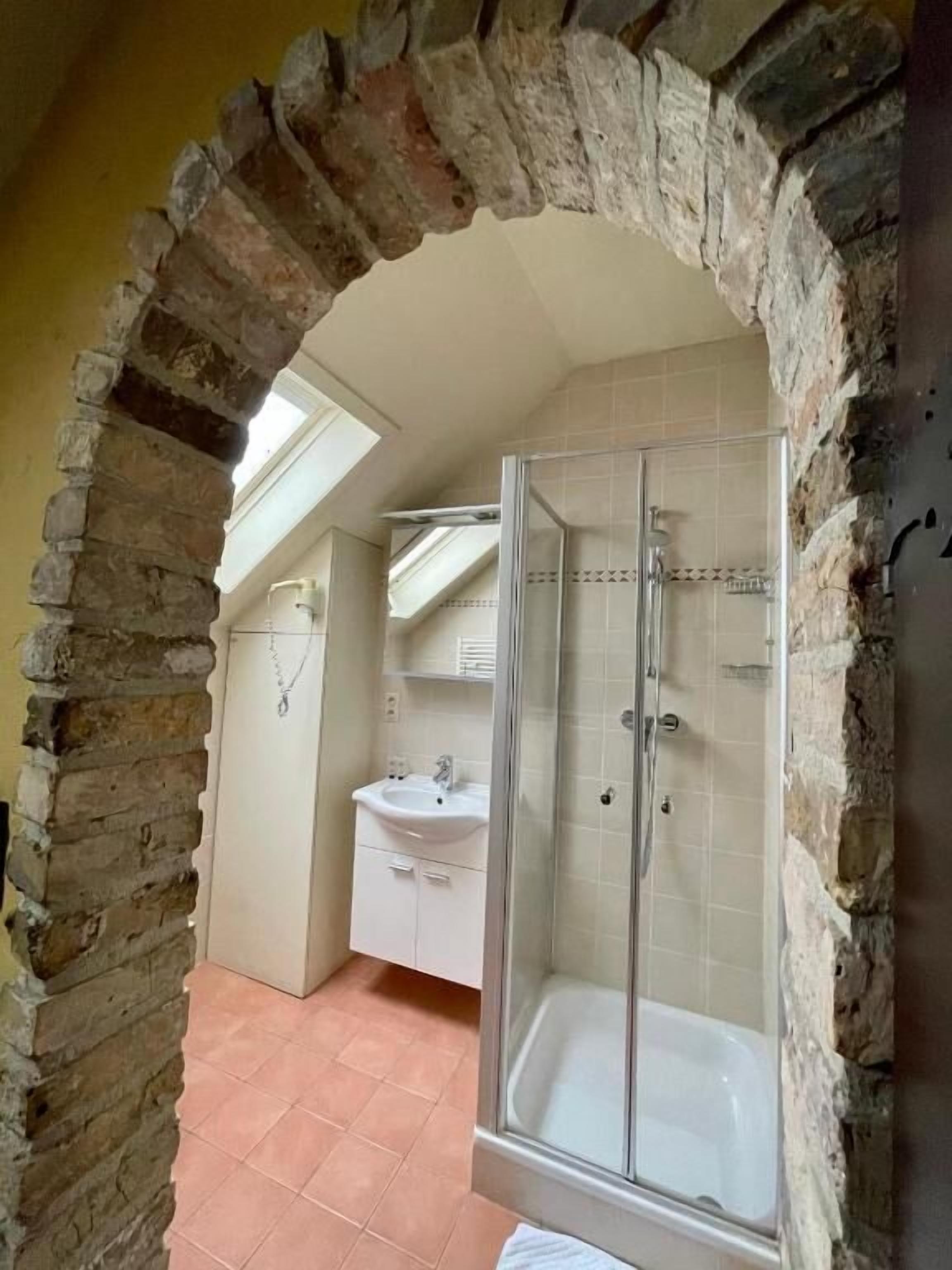 Een badkamer met een douche, wastafel en bad.