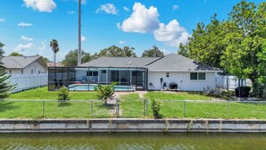 A residential property with a swimming pool, a covered patio, and a fenced yard. - Villa Turtle View right on the water (Cape Coral)