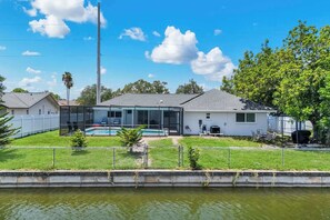 Ein Wohnhaus mit Swimmingpool, überdachter Terrasse und umzäunter Garten.