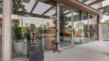 A modern building with large glass windows, a visible address number 815, and a seating area outside.