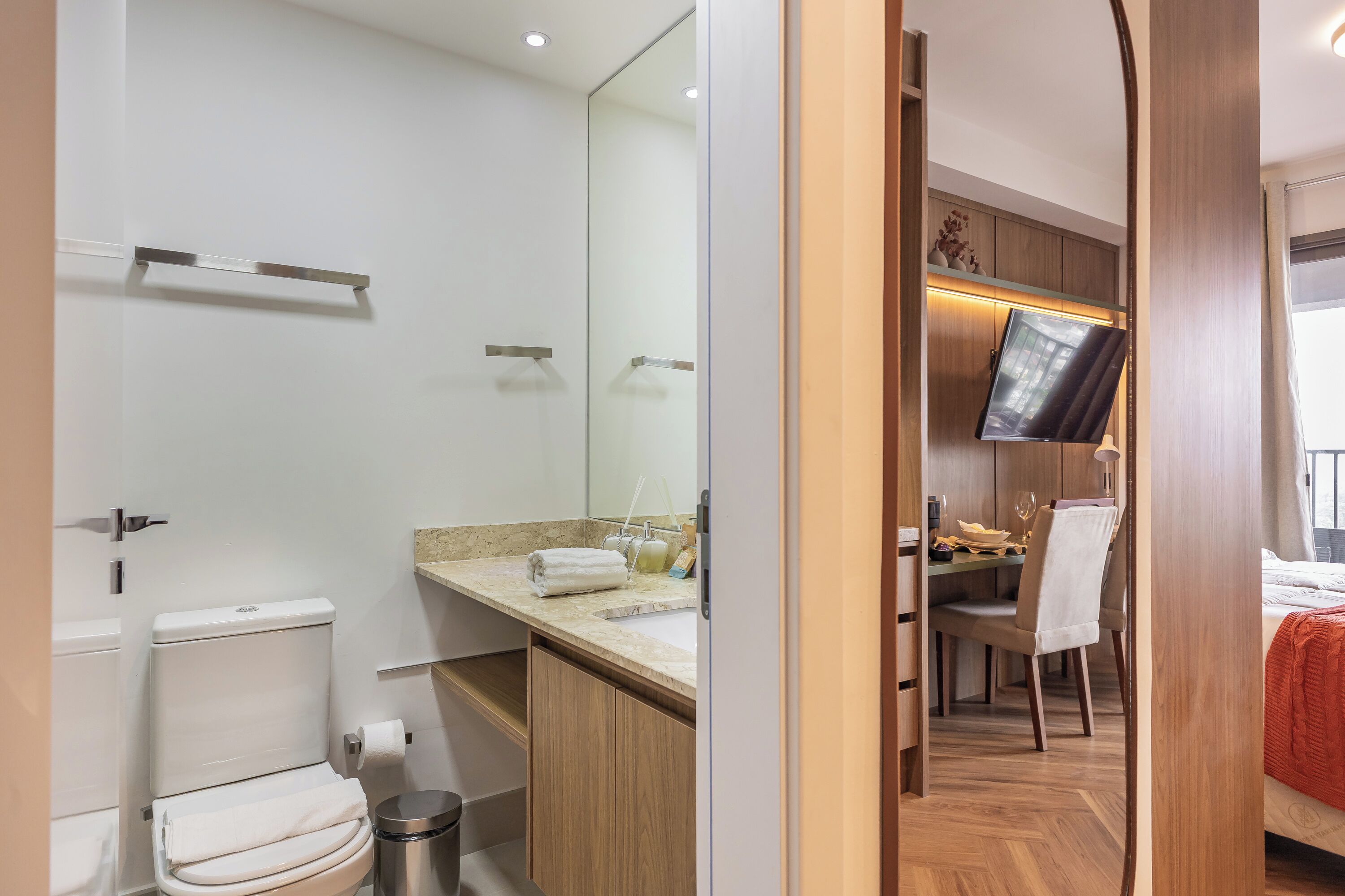 Une salle de bain moderne avec des toilettes, un lavabo et un miroir.