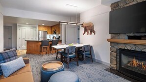 A modern living room with a fireplace, a dining area, and a kitchen in the background. - 1 Bedroom Villa Timber Lodge Resort S Lake Tahoe (South Lake Tahoe)