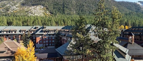 A hotel with multiple buildings, a central courtyard, and a mountainous backdrop.